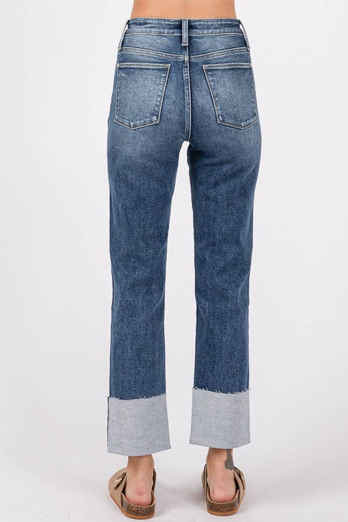 Blue jeans with cuffed hems on a white background