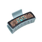Decorative hair clip with intricate designs on a white background