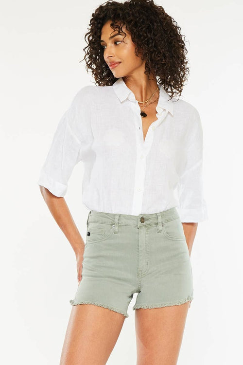Woman wearing a white shirt and light green shorts on a white background