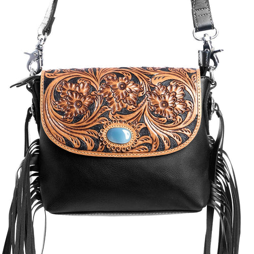 Black handbag with floral tooled leather design and tassels on a white background
