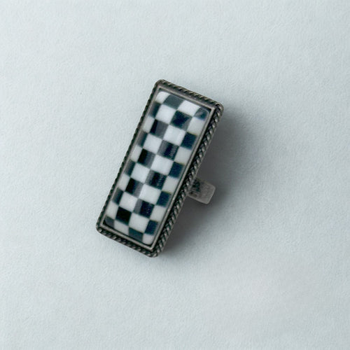 Rectangular object with a checkered pattern on a light gray background