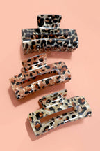 Set of leopard print hair clips on a pink background
