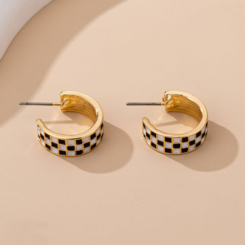 checkered huggie earrings on display table