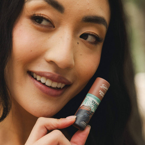 Woman holding a lipstick with a blurred background