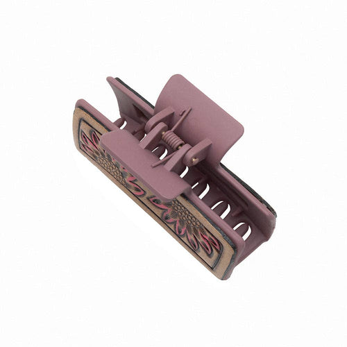 Pink hair clip with decorative patterns on a white background