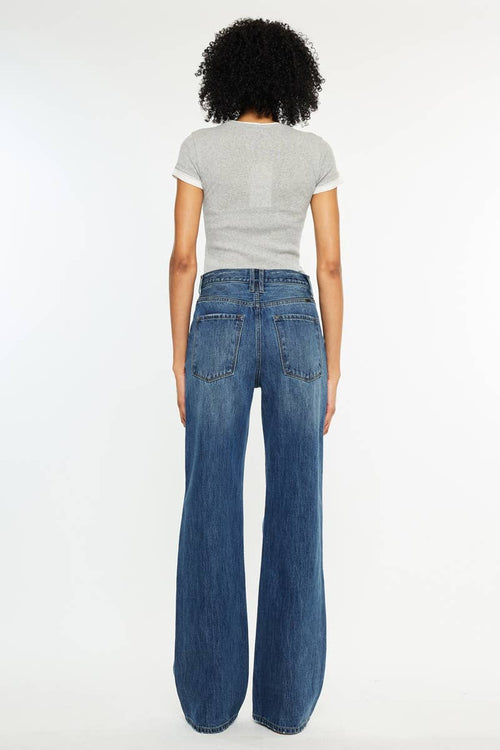 Person wearing a gray t-shirt and blue jeans on a white background