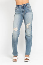 Light blue jeans with distressing on a white background