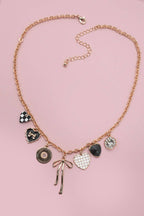 Necklace with various charms on a pink background