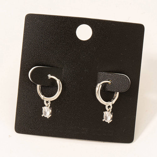 Pair of silver hoop earrings with a small gemstone on a black card.