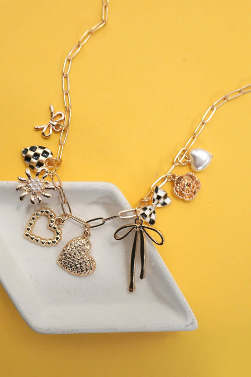 Necklace with various charms on a yellow background
