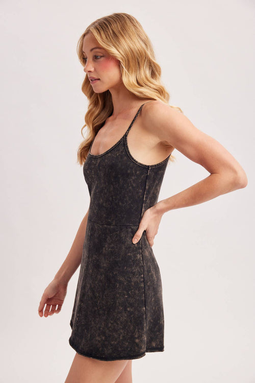 Woman wearing a black patterned dress on a light gray background