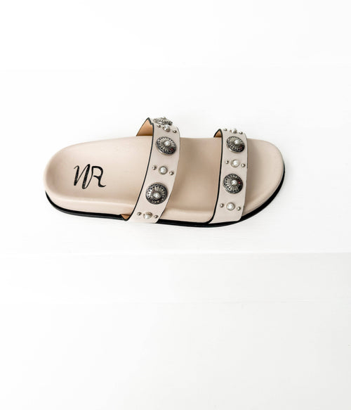 Beige sandal with decorative straps and 'MR' logo on a white background