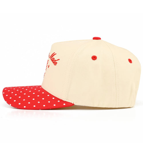 Beige and red cap with polka dot brim on a white background