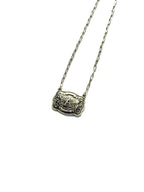 Silver necklace with a decorative pendant on a white background