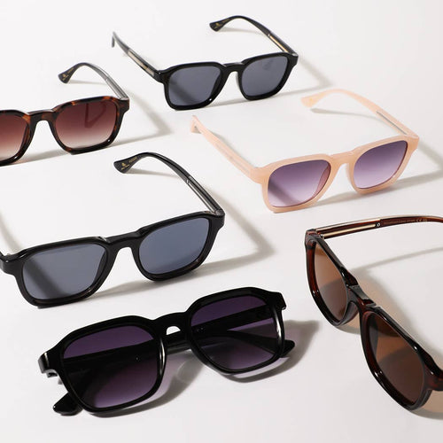 Collection of sunglasses with different frame colors and lens types on a light background