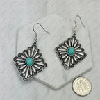 Silver floral earrings with turquoise centers on a white background