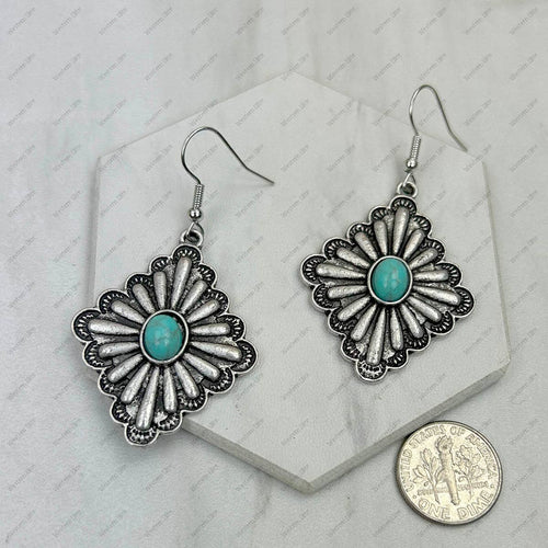 Silver floral earrings with turquoise centers on a white background