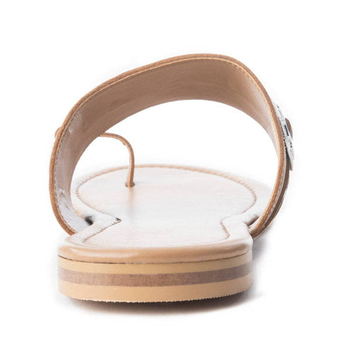 Close-up of a sandal with a white sole and tan strap on a white background