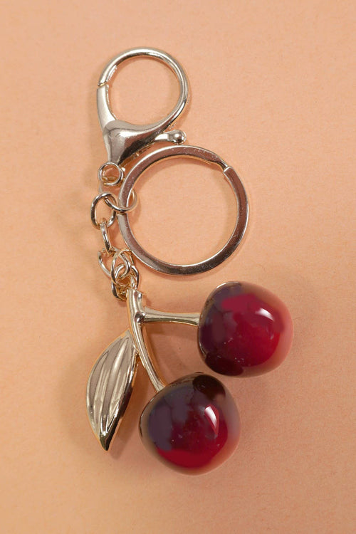 Keychain with cherry design on a beige background