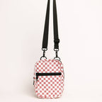 Red and white checkered pouch with a black strap on a light beige background