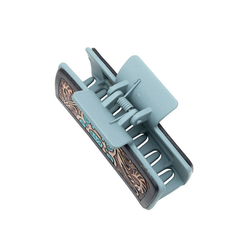 Light blue hair clip with decorative pattern on a white background
