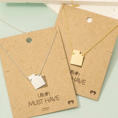 Two necklaces on brown paper with 'Utah Must Have' text on a light green background