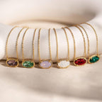 Set of gold necklaces with colorful gemstones on a white surface