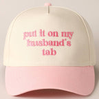 Beige and pink cap with text 'put it on my husband's tab' on a light gray background