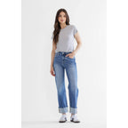 Woman wearing a gray t-shirt and blue jeans on a white background