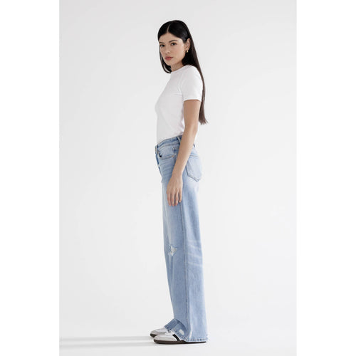 Woman wearing light blue jeans and a white t-shirt on a white background