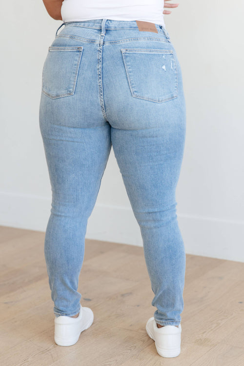Light blue jeans worn by a person on a plain background