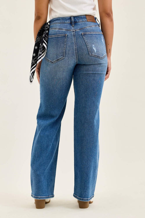 Person wearing blue jeans on a plain background