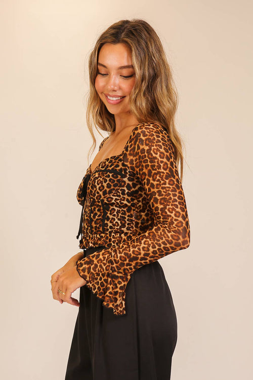 Woman wearing a leopard print top against a beige background