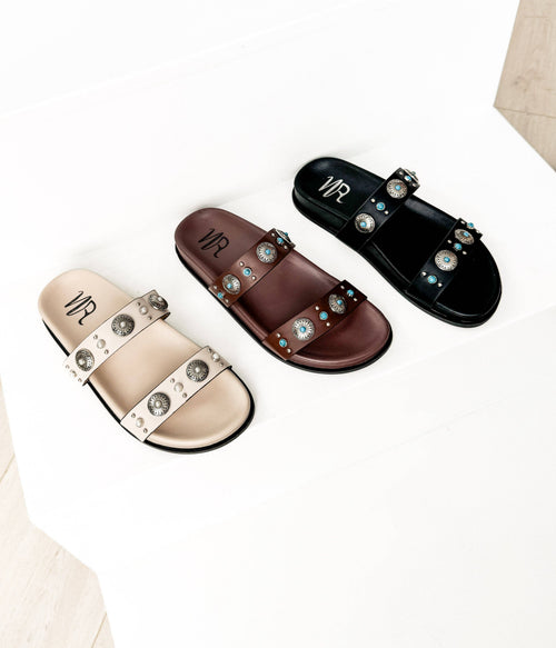 Three sandals in beige, brown, and black with embellishments on a white background