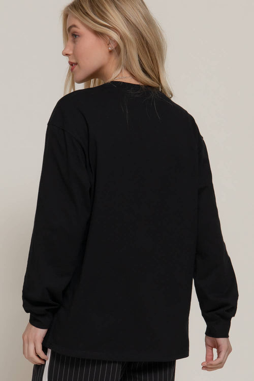 Person wearing a black sweater against a plain background