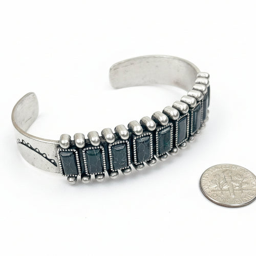 Silver bracelet with black stones on a white background