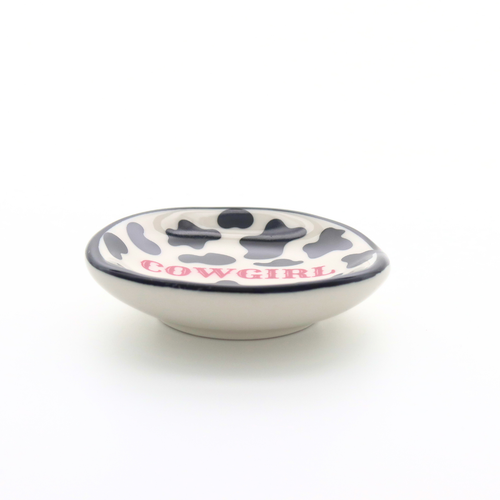 Small ceramic bowl with cow print design and 'Cowgirl' text on a white background