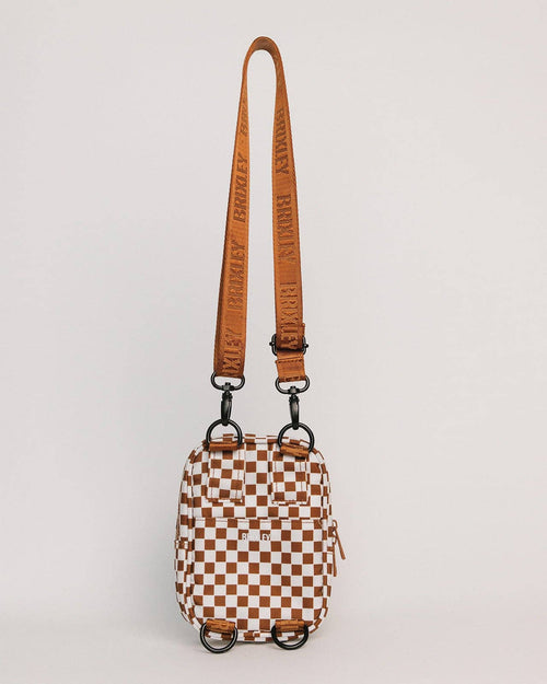 Checkered bag with a brown strap on a light gray background