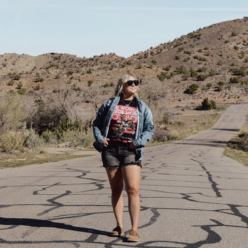 Person standing on a road with a mountainous landscape in the background