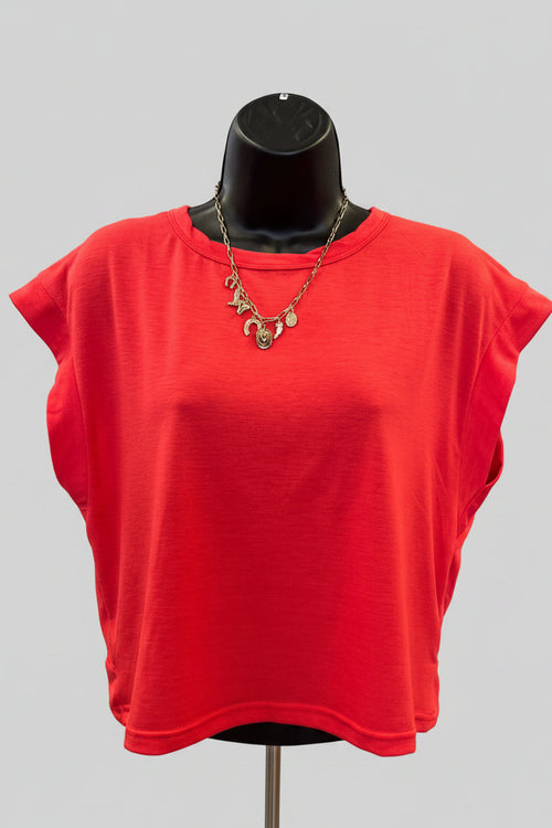 Red dress on a mannequin in a store setting with shelves in the background