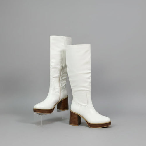 White knee-high boots with brown block heels on a gray background