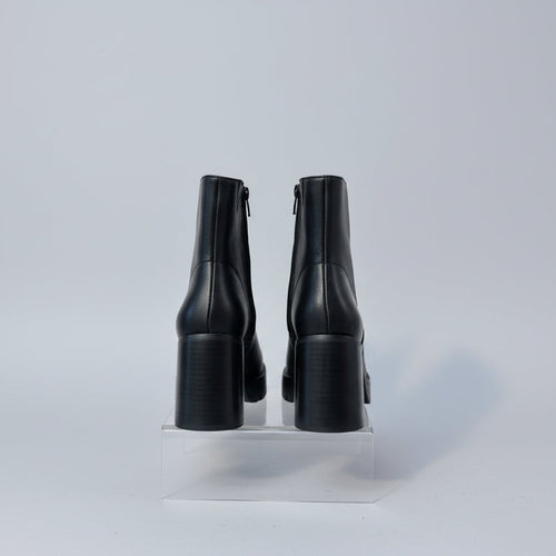 Black ankle boots with a white background