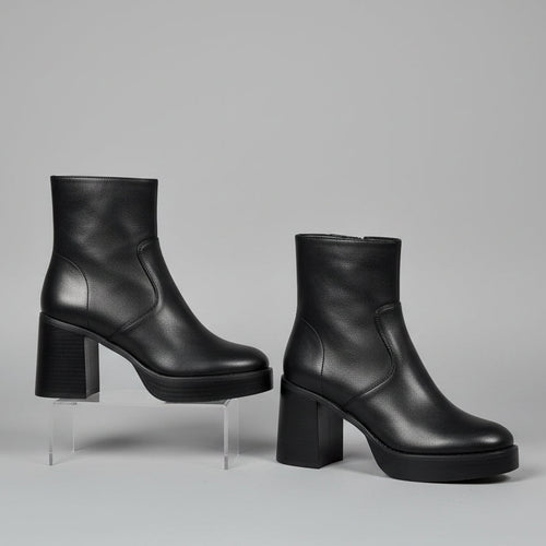 Black ankle boots with a white background