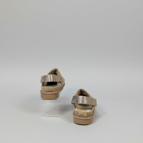 Pair of brown shoes with straps on back on a white background 