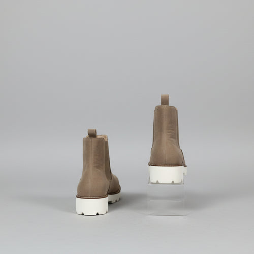 Brown Chelsea boots on a white surface 