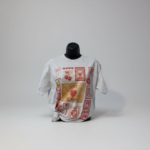 Gray t shirt with love-themed graphics on a mannequin against a white background