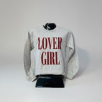 Gray sweatshirt with 'LOVER GIRL' text on a mannequin against a plain background