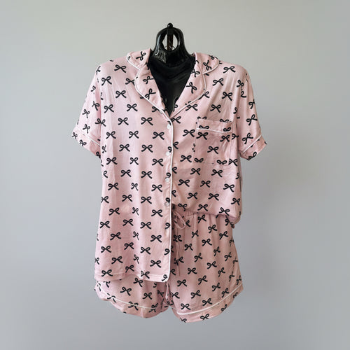 Pink pajama set with black bow pattern on a white background
