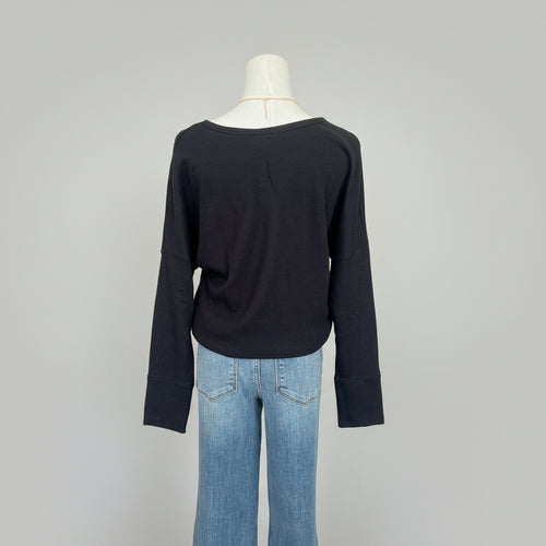 Mannequin wearing a black long-sleeve shirt and blue jeans with a white background 