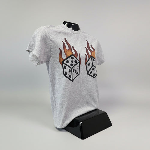 Gray t-shirt with dice and flame design on a grey surface